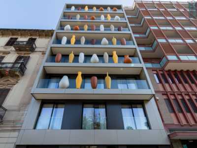 ...quando l�intero prospetto � stato arricchito da imponenti giare colorate di diverse forme realizzate in poliuretano espanso, inserite nei pannelli trasparenti dei parapetti 